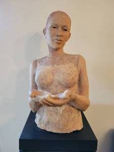 A signed terra cotta half length statue of a lady.  Comes with a swivel pedestal.