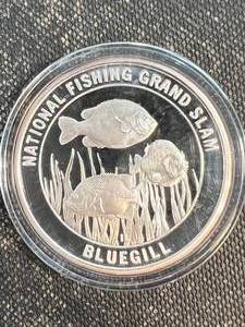 lot 51 image: 1 TROY OZ .999 FINE SILVER NORTH AMERICAN FISHING CLUB ROUND IN AIRTITE