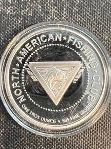 lot 54 image: 1 TROY OZ .999 FINE SILVER NORTH AMERICAN FISHING CLUB ROUND IN AIRTITE