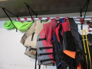 Assortment of life jackets, fishing pole and outdoor seasonal decor