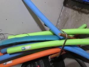 Armful of swimming pool floating noodles