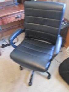 Black padded rolling and adjustable office chair appears to be in new condition