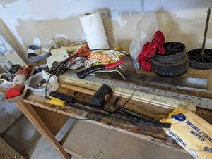 Assortment of pry bands, yard sticks, drywall square, hatchet and more