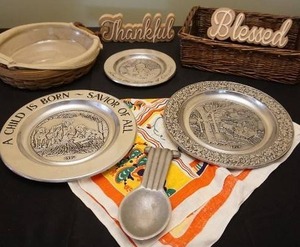 lot 26 image: Table Top DeCor Pewter Christmas Plate, Vintage 1930s Tony Sarg Table Linen Cloth Colorful Folk Pattern, Basket Etc.