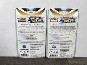 lot 13 image: POKEMON BRILLIANT STARS Flapple & Eevee Booster Packs (2 - Unopened packs with coin in the front)