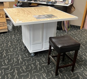 lot 223 image: Portable Merchandise Table with plexiglass lift top for inserting advertising documents. Square stool with padded seat included
