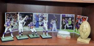 lot 289 image: Vikings Memorabilia (4) NFL Statues of Brett Favre #4 LE replica of Metrodome Stadium. Vikings Carved Football. (4) Photos