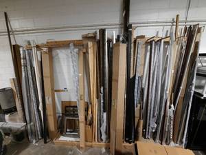 lot 517 image: All framing wood moulding along the wall. Biggest piece is 148. A few assembled frames.