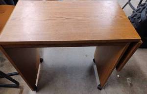 lot 71 image: Small Table on Casters with a Drop Leaf at One End, Measures 27-inches Long X 15.25-inches Wide X 28.25-inches Tall, the Drop Leaf is 11.75-inches Long
