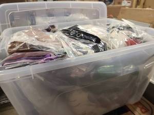 Storage bin of new clothing still in wrap, mostly womens