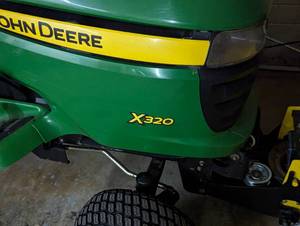 lot 2 image: John Deere X320 Lawn Tractor with Plow Attachment