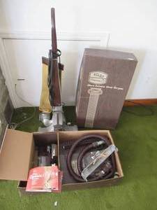 lot 74 image: Vintage Kirby Vacuum Cleaner with many accessories in box.