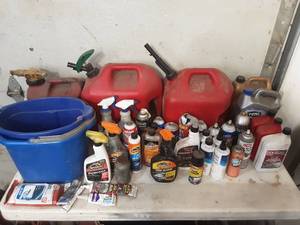 3 gas cans and large assortment of partially full cleaning and automotive chemicals