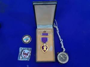 Purple Heart military medal, two service coins and a compass state in 1940