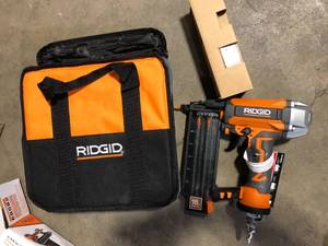 lot 19 image: RIDGID Pneumatic 18-Gauge 2-18 in. Brad Nailer with CLEAN DRIVE Technology, Tool Bag, and Sample Nails  Customer Returns See Pictures