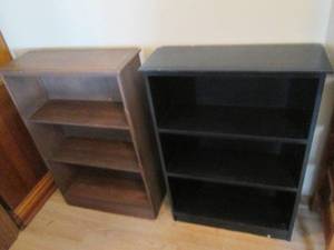 Pair of (2) wood book shelves. One unit on done in an elegant yet ridgid darker shade while the other boasts a bolder black tone making more of a modern day statement