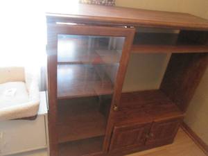 Wood entertainment multimedia cabinet with glass front door to the one side and a pair of concealing underneath storage doors