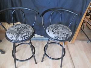 Black Metal framed with fancy Upholstered seats is a pair of stationery Swiveling stools