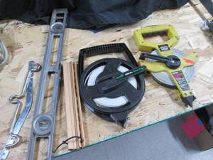 lot 101 image: Pair of 100ft measuring tape reels, level and other supplies