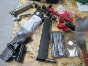 lot 114 image: Mini grease gun, broom stand, pick tools and other supplies