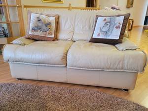lot 6 image: Cream colored Leather Loveseat.