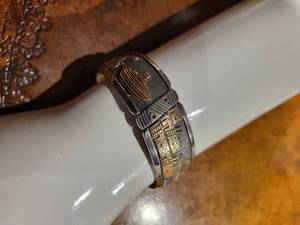 lot 54 image: A Sterling Silver and 10K Gold Ray Calladitto Navajo Storyteller Cuff Bracelet.