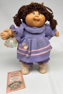 lot 73 image: Vintage Loop Bangs CABBAGE PATCH Brunette Original Tags in a Purple Knit Duckie Dress DARLENE ISABEL