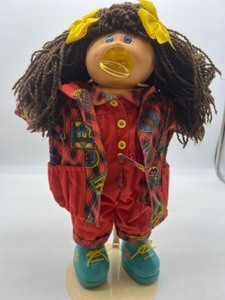 lot 84 image: Vintage CABBAGE PATCH Kinky Brown Hair Paci Girl in Designer Line Clothing
