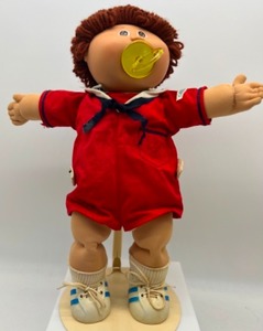 lot 173 image: Cabbage Patch Poodle Loop Auburn Hair Red Sailor Romper Paci Boy Doll