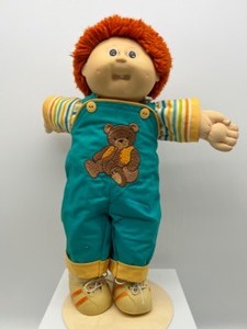 lot 16 image: Vintage CABBAGE PATCH Fuzzy Red Head Boy with one Front Tooth in Teddy Bear Overalls