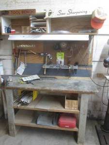 Large tool bench with content including bench vise, grinding discs, polishing kit, wire brushes and content pictured