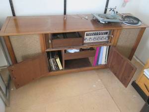 Vintage AMFM Record player Console Unit with accordion style doors to conceal the controls as well as cupboard style doors that open to reveal open storage and a pull out drawer&nbsp