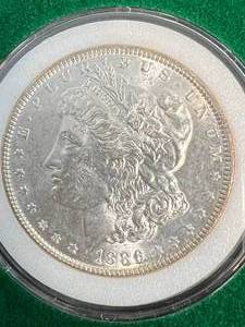 lot 34 image: 1886 US MORGAN SILVER DOLLAR IN GREEN CASE