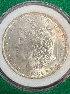 lot 72 image: 1884-O US MORGAN SILVER DOLLAR IN GREEN CASE