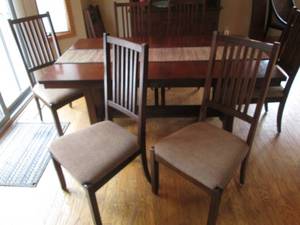 lot 1 image: Missionary Style Slasted wood Dining room table with 6 matching neutral toned padded chairs. Includes 1-leaf for expansion