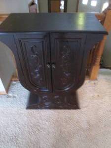 lot 2 image: Dark wood Wine Glass shaped 2-door Console Cabinet with a scrolling floral applique pattern