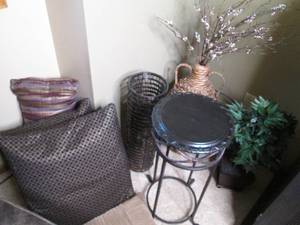 lot 55 image: Petite decorative table with an assortment of woven floor decor, faux greenery and abstract design accent pillows