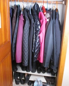 lot 59 image: Entry closet content to include a variety of Womens casual lightweight outerwear with a few Quilted pieces, plus an assortment of boots and other footwear ranging in sizes 9-10, along with gloves, hats and other Misc