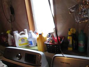 lot 93 image: Ledge of laundry soaps and supplies plus a variety of other household cleaners, supplies and accessories