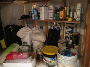 lot 100 image: Under the stairs corner lot of household and specialty paints and stains, Driveway blacktop coating, adhesives, rolling luggage and more