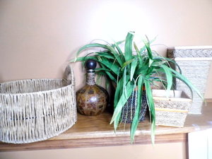lot 168 image: Wicker Rattan wrapped basket and vase decor alongside a wrapped lidded Decanter displaying a map in deep neutral shades