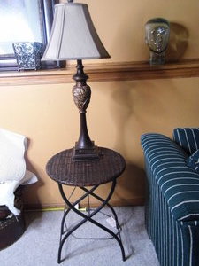 lot 174 image: Dark tone Metal framed table either Wicker Rattan top and decorative tower-like carved detail table lamp with shade