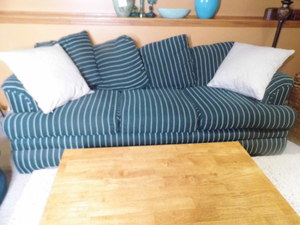 lot 176 image: Hunter Green solid Oversized relaxing chair with striped accent pillow, Matching Striped 3-cushion sofa with solid accent pillows and Missionary Style light tone coffee table furniture trio