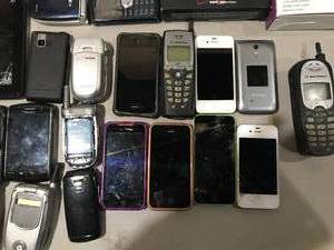 lot 84 image: Lot of old used cellular phones - Apple iPhones, LG, Samsung and misc. chargers.