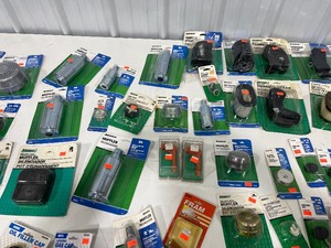 TABLE FULL OF SMALL ENGINE PARTS, & WEED WACKER PARTS