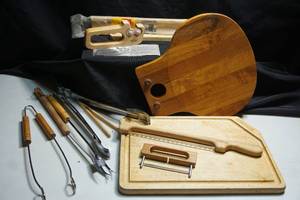 lot 220 image: Cutting Boards, Grilling Utensils, Vintage Wusthof Trident Ceramic Knife Sharpener, Mountain Woods Bow Bread Knife, Nissen Denmark Charcuterie Cheese Board, Corn Cutter Etc.