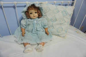 lot 344 image: Antique Doll 1930-40s American Character Chuckles  Blue Eyes Composition and Vintage Crocheted Style Pillow