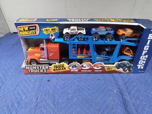 lot 131 image: Toy Semi with car hauler trailer of monster trucks