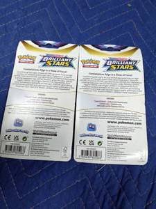 lot 187 image: Pokmon Brilliant Stars Flapple and Eevee boosters. 2 unopened pks with coin in front