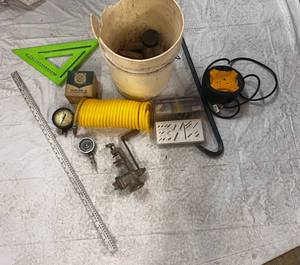 lot 77 image: Bucket With Multiple Socket Extension Cord, Compression Tester,Fuel Pump Tester, Air Hose, Springs, S Hooks & More